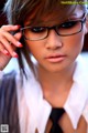 A woman wearing glasses and a white shirt.