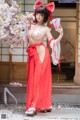 A woman in a red and white kimono posing for a picture.