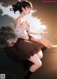 A girl in a brown skirt and white blouse sitting on a ledge.