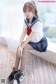 A woman in a school uniform sitting on a window sill.