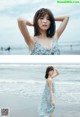 A woman standing on a beach next to the ocean.