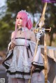 A woman with pink hair holding a sword.