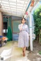 A woman in a pink dress standing in a courtyard.