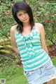 A young woman in a green and white striped top and denim skirt.