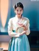 A young girl in a blue and white hanbok.