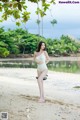 A woman in a white bathing suit standing on a beach.